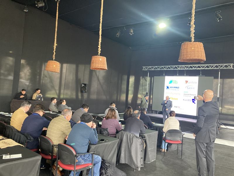 Asistentes en la sala de sesiones mientras se presenta la lámina de patrocinadores